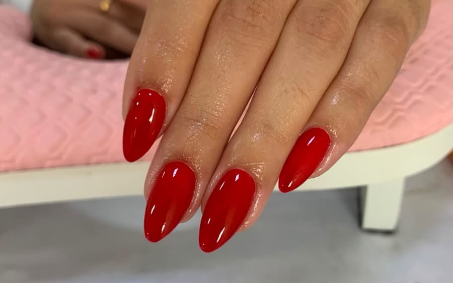 Unhas amendoadas com esmaltação em gel vermelha, feitas no Morena Café